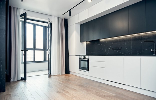  Фартук черного цвета объединяет столешницу и верхний ряд фасадов кухонного гарнитура, смотрится выразительно и акцентирует внимание на рабочей зоне