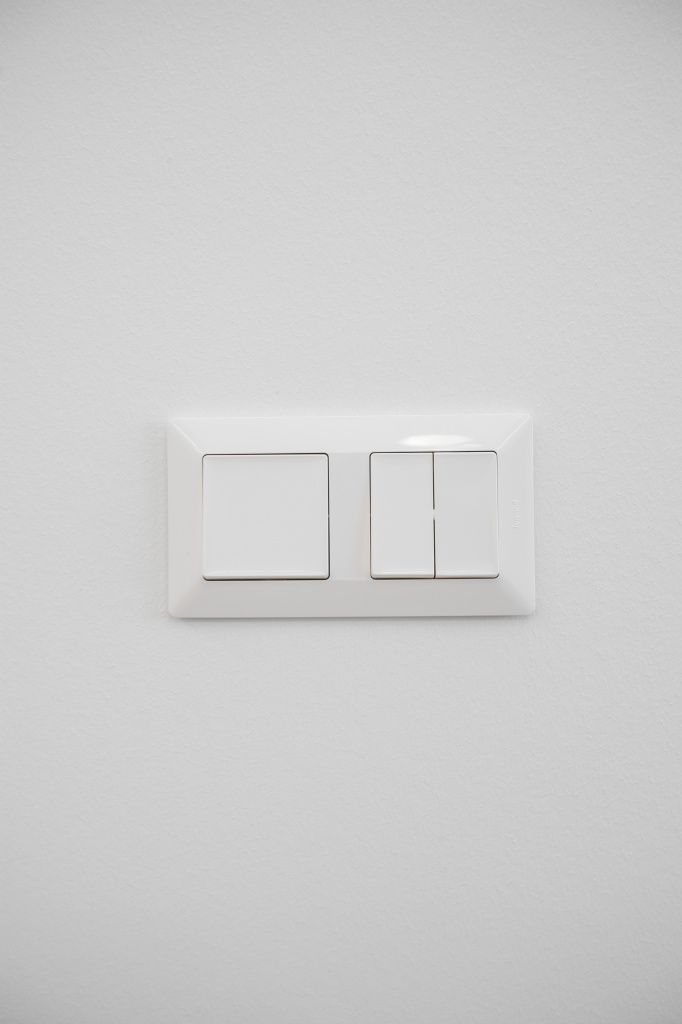 Белые выключатели на фоне белых стен