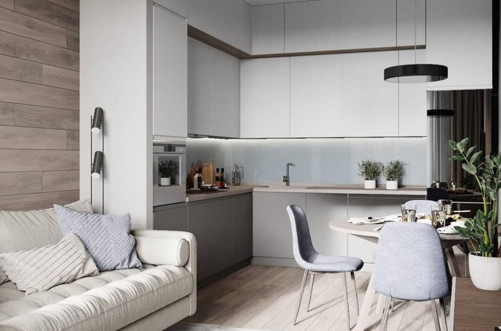 Дизайн кухни гостиной в квартире, расположена светлая мебель, планировка угловая, есть компактная обеденная зона
